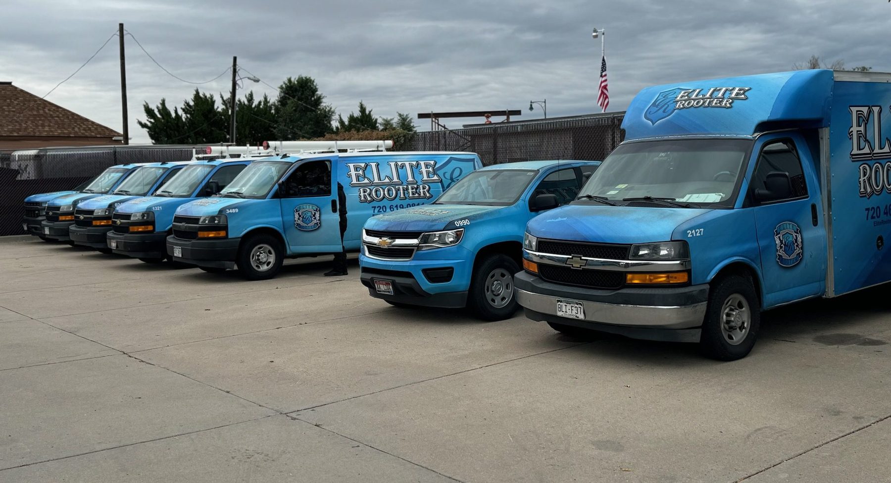 Blue Elite Rooter service vans and trucks parked together